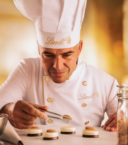 Eine Familie sitzt rund um einen weihnachtlich dekorierten Tisch (Photo)